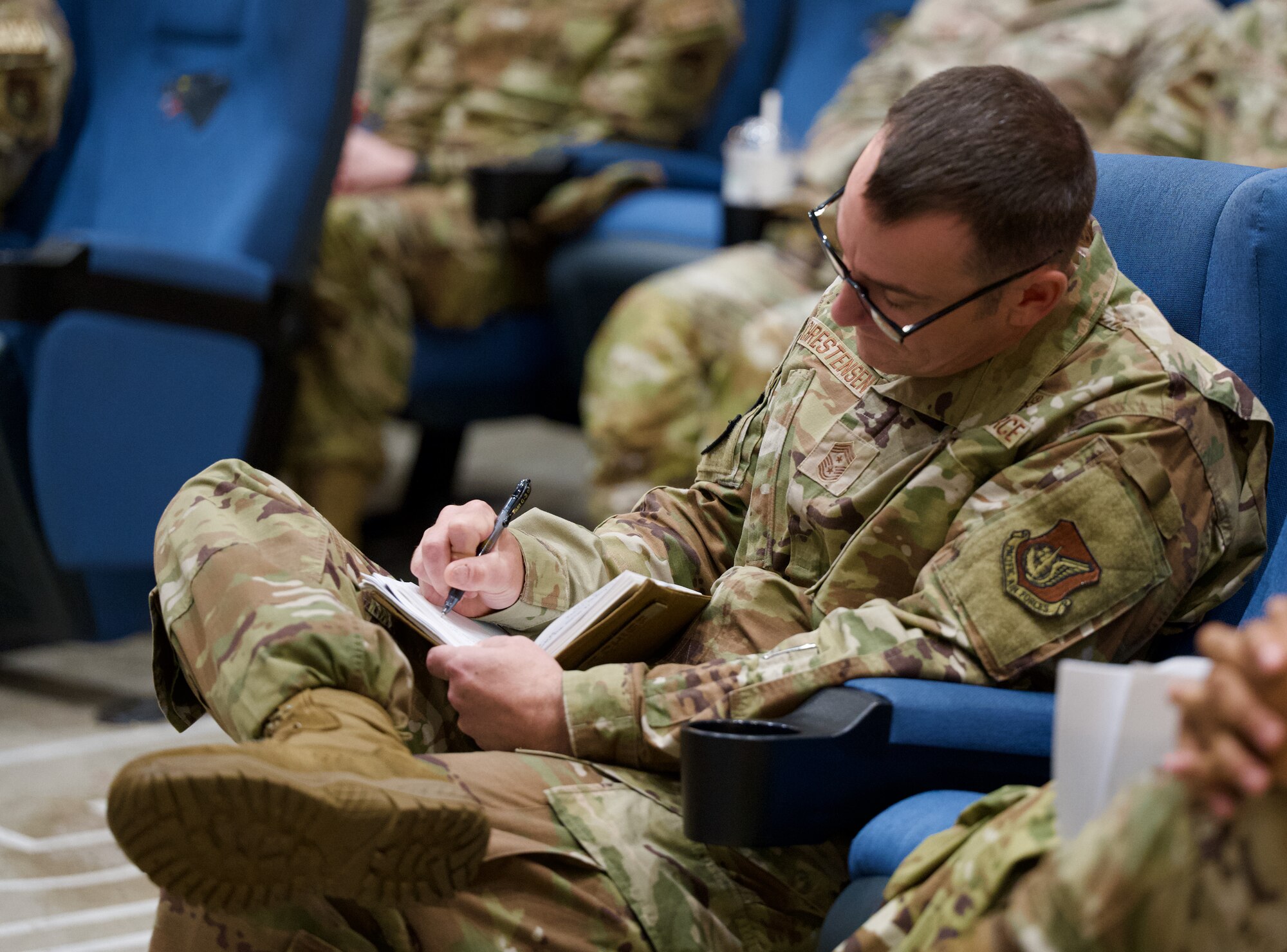 U.S. Air Force Chief Master Sgt. Nathan Christensen, 8th Fighter Wing command chief, takes notes as Chief Master Sgt. Jeremiah Ross, 7th Air Force command chief, addresses members of the Wolf Pack.