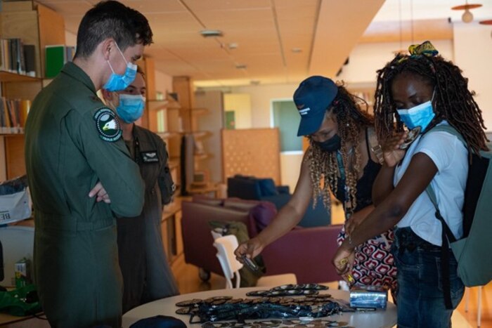2 pilots stand and converse with 2 civilians