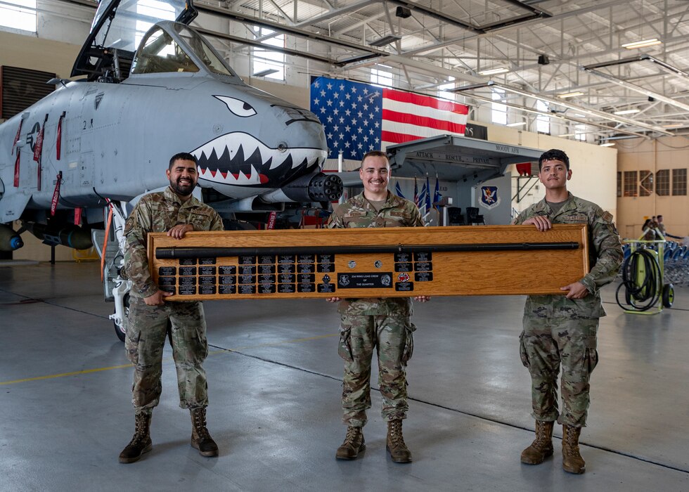 U.S. Air Force Airman 1st Class Cecilio Borboa (left), 75th Fighter Generation Squadron load crew member, U.S. Air Force Staff Sgt. Kyler Wilson (center), 75th FGS load crew chief, and U.S. Air Force Airman 1st Class Jonathan Morales (right), 75th FGS load crew member, hold a load competition trophy at Moody Air Force Base, Georgia, July 11, 2024. Every quarter the best weapons Airmen from the 74th and 75th FGS’s compete in a loading competition to find the most proficient crews and boost morale. (U.S. Air Force photo by Airman 1st Class Leonid Soubbotine)