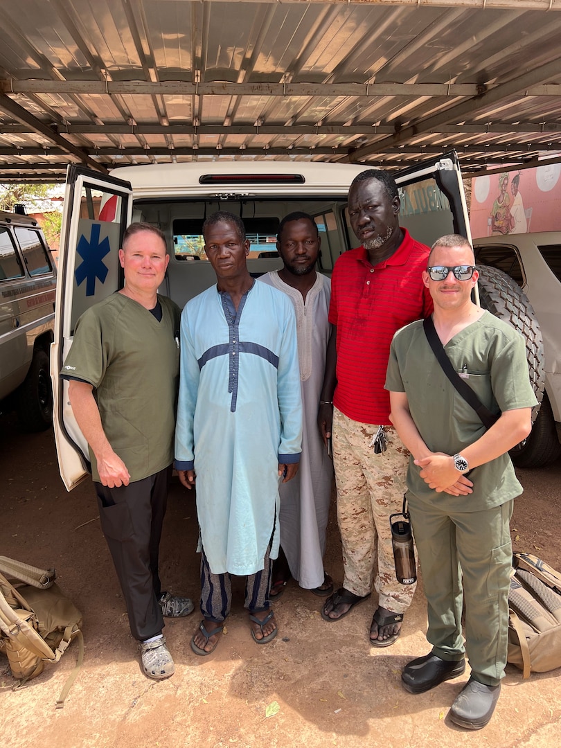 U.S. Army Lt. Col Christopher Winner and Staff Sgt. Jeffrey Frizzell, Vermont National Guard, pose with an ambulance crew at the Goudiri health care center in Goudiri, Senegal.