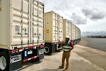 FEMA employee gesturing toward trailer labeled "Water"