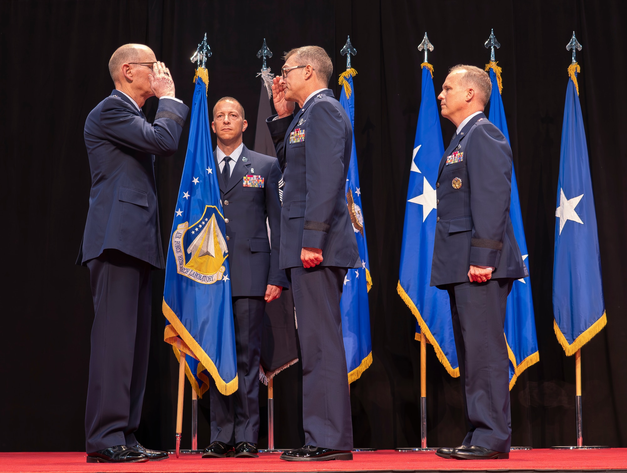 Outgoing Air Force Research Laboratory, or AFRL, Commander Maj. Gen. Scott A. Cain, middle, offers a final salute to Gen. Duke Z. Richardson, commander, Air Force Materiel Command, left, before relinquishing command of AFRL to Brig. Gen. Jason E. Bartolomei, right, at a change of command ceremony held at the National Museum of the United States Air Force in Dayton, Ohio, July 10, 2024. Cain will assume command of the Air Force Test Center at Edwards Air Force Base, California on July 30.  “[This move] in particular is a tough one because this community has been so good to us,” Cain said. “It’s been an honor to lead AFRL and absolutely a highlight of my career.” (U.S. Air Force photo / Keith Lewis)