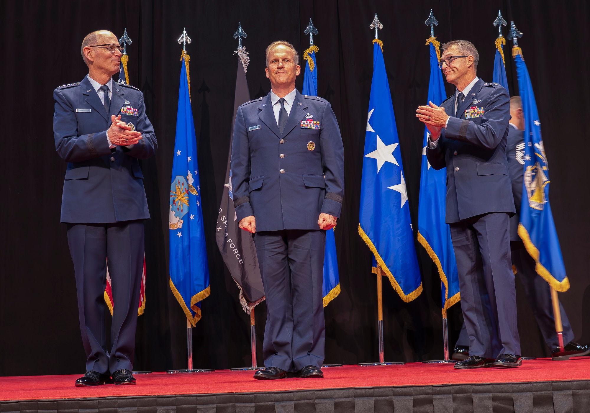 Gen. Duke Z. Richardson, commander, Air Force Materiel Command, left, and outgoing Air Force Research Laboratory, or AFRL, Commander Maj. Gen. Scott A. Cain, right, applaud as Brig. Gen. Jason E. Bartolomei, middle, is formally announced as AFRL Commander at a change of command ceremony at the National Museum of the United States Air Force in Dayton, Ohio, July 10, 2024. “I have full confidence that Gen. Bartolomei is going to continue to build on our momentum and lead this team through this era of technological competition,” Cain said. (U.S. Air Force photo / Keith Lewis)