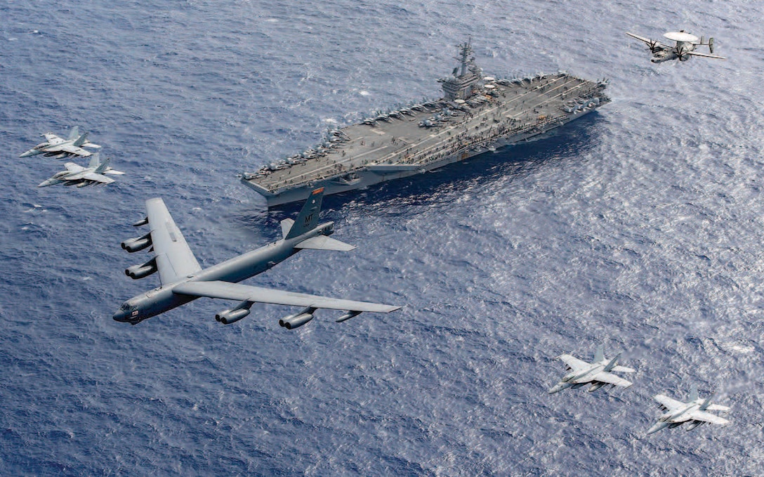 Air Force B-52 Stratofortress leads five other aircraft in formation above aircraft carrier USS Theodore Roosevelt during routine operations in
Philippine Sea, February 24, 2024