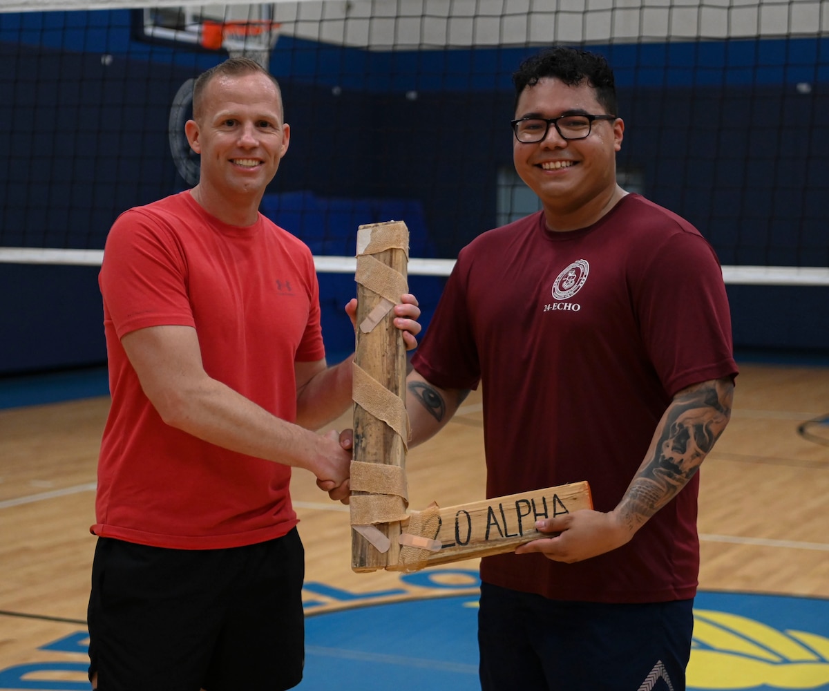 U.S. Air Force Chief Master Sgt. Michael Nolan, 17th Communications Squadron senior enlisted leader, hands the “L” to Senior Airman Marcelo Chapa, Airman Leadership School Class 24-E leader, at the Mathis Fitness Center, July 9, 2024. Every ALS class plays a volleyball game with the first sergeants, and the winning team presents the “L” to the losing team. (U.S. Air Force photo by Airman 1st Class Madison Collier)