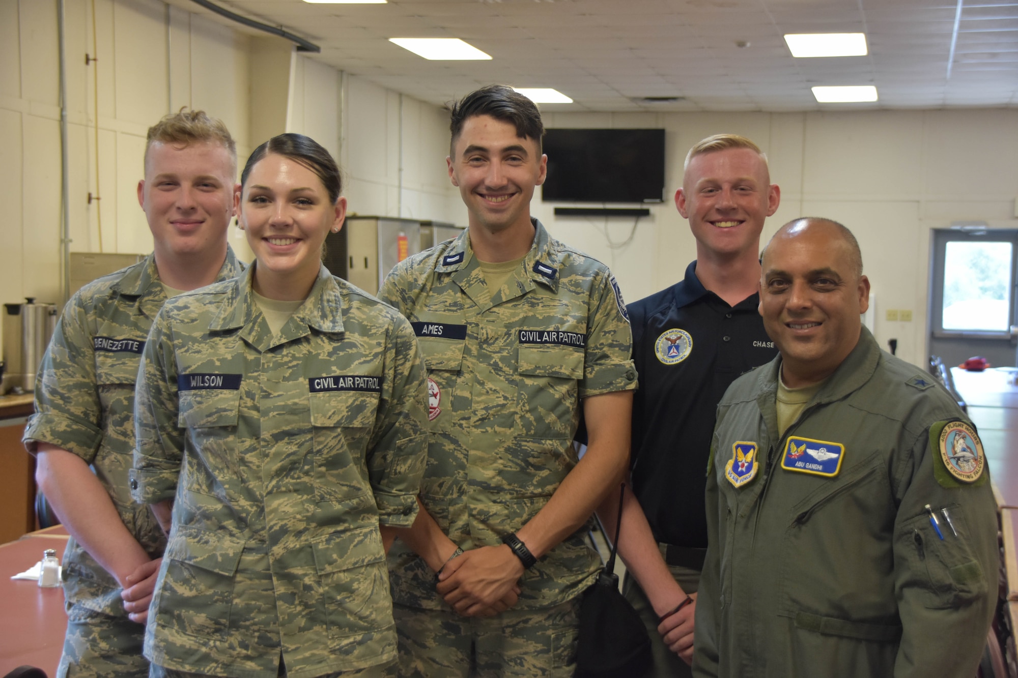 air force volunteers and a pilot pose for a photo