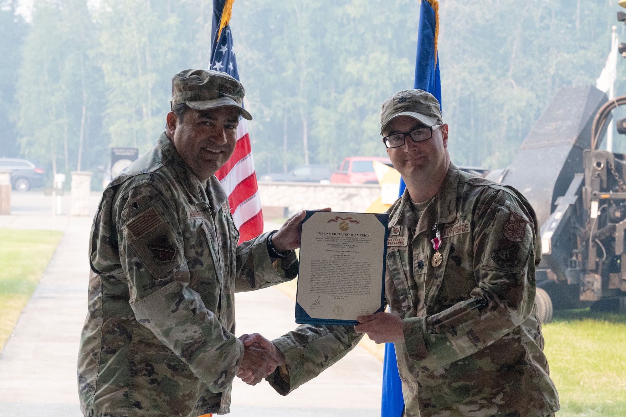 An Airman receives a meritorious service medal certificate.