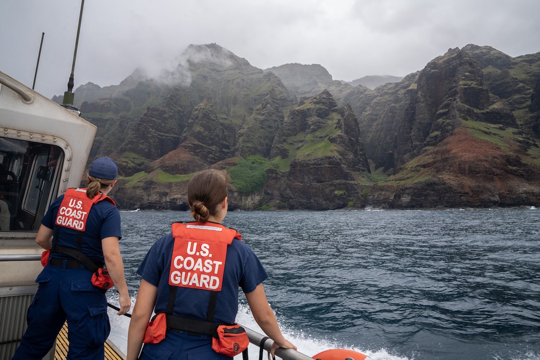 U.S. Coast Guard Petty Officer 1st Class Lindsy Martin (left) and Petty Officer 3rd Class Kai Hall, two U.S. Coast Guard Station Kauai members, stand on the aft deck of a 45-foot response boat while conducting a patrol around the island of Kauai, Hawaii, May 23, 2024. U.S. Coast Guard Station Kauai conducts an area of responsibility familiarization patrol around the island of Kauai, Hawaii. (U.S. Coast Guard photo by Petty Officer 2nd Class Tyler Robertson)