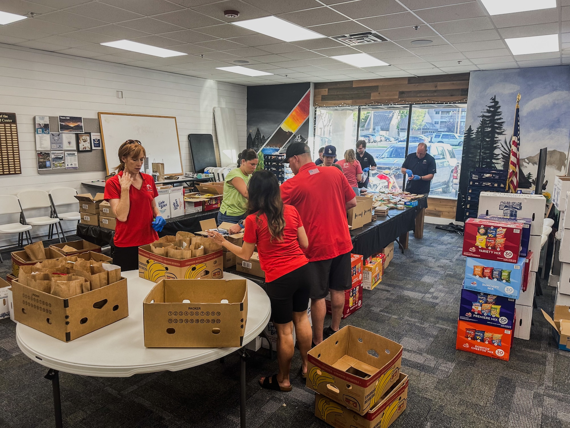 Volunteers package brown sack lunches.