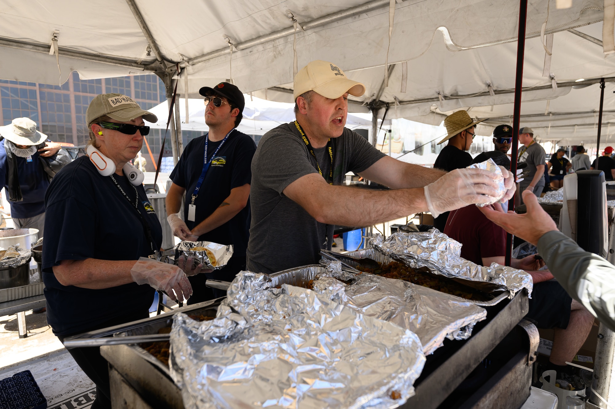 Volunteers hand food to a patron.