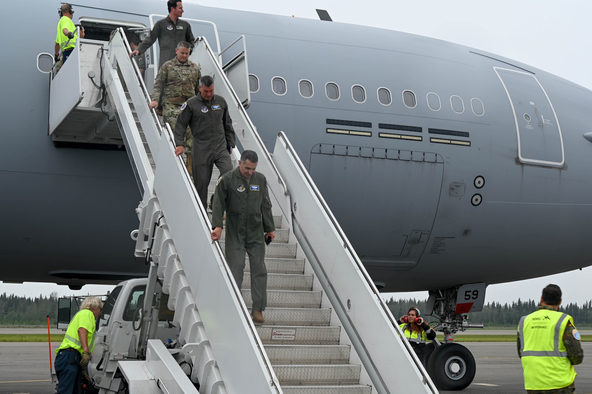 Lt. Gen. David Nahom, commander of Alaskan NORAD Region, Alaskan Command, and Eleventh Air Force, walks down stairs to exit an aircraft with 3 other members.