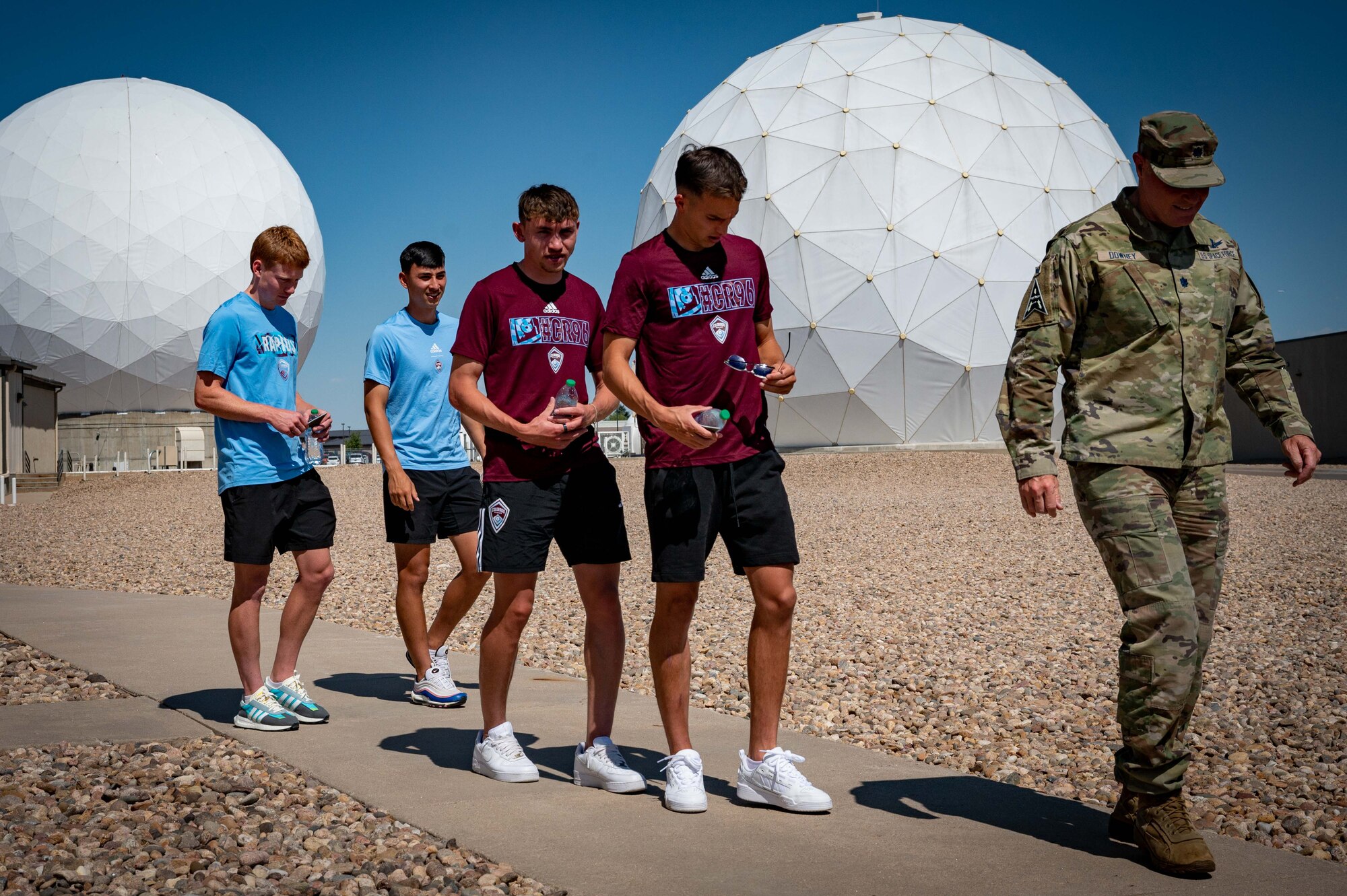 men walk in front of domes