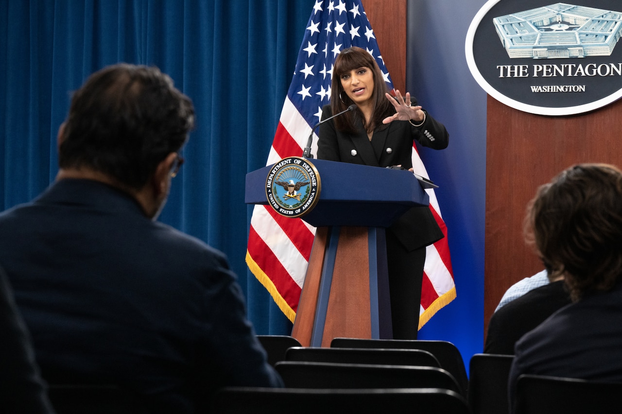 A woman stands behind a lectern.