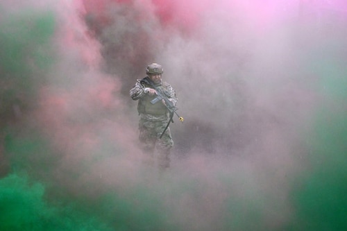 Staff Sgt. Manuel Estrada, 433rd Contingency Response Flight specialist, performs fire team procedures using blank ammunition and smoke grenades at the Contingency Location Operations Rehearsal (CLOR 24) in Alpena, Michigan June 25, 2024.