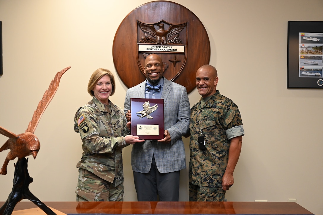 Military personnel and a civilian pose for a photo.