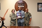 Military personnel and a civilian pose for a photo.