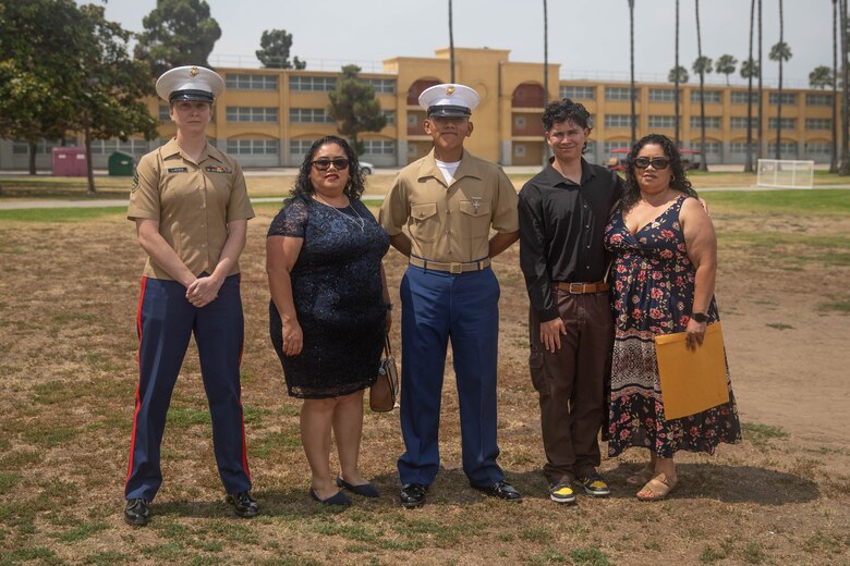 U.S. Marine Corps Pvt. Carlos Paz-Sosa, center, a Marine with India Company, 3rd Recruit Training Battalion, Recruit Training Regiment, and Staff Sgt. Aubrey Larsen, Paz-Sosa's recruiter in Riverside County, California, far left, and family members pose for a group photo following a graduation ceremony at Marine Corps Recruit Depot San Diego, California, July 12, 2024. Paz-Sosa was highlighted due to his impressive transformation, losing more than 100 lbs. in order to become a Marine. (U.S. Marine Corps photo by Cpl. Elliott A. Flood-Johnson)