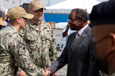 Lt. Cmdr. Zachary Smith, Continuing Promise 2024 Mission Commander, and Lt. Daniel Ehrlich, Continuing Promise 2024 Public Affairs Officer, greet U.S. Ambassador to Jamaica N. Nick Perry prior to his visit and tour of Spearhead-class expeditionary fast transport ship USNS Burlington (T-EPF 10) at Kingston Wharves.