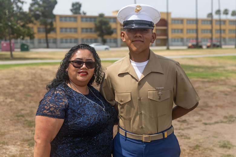 U.S. Marine Corps Pvt. Carlos Paz-Sosa, right, a Marine with India Company, 3rd Recruit Training Battalion, Recruit Training Regiment, and Maria Sosa, Paz-Sosa's mother, left, pose for a photo following a graduation ceremony at Marine Corps Recruit Depot San Diego, California, July 12, 2024. Paz-Sosa was highlighted due to his impressive transformation, losing more than 100 lbs. in order to become a Marine. (U.S. Marine Corps photo by Cpl. Elliott A. Flood-Johnson)