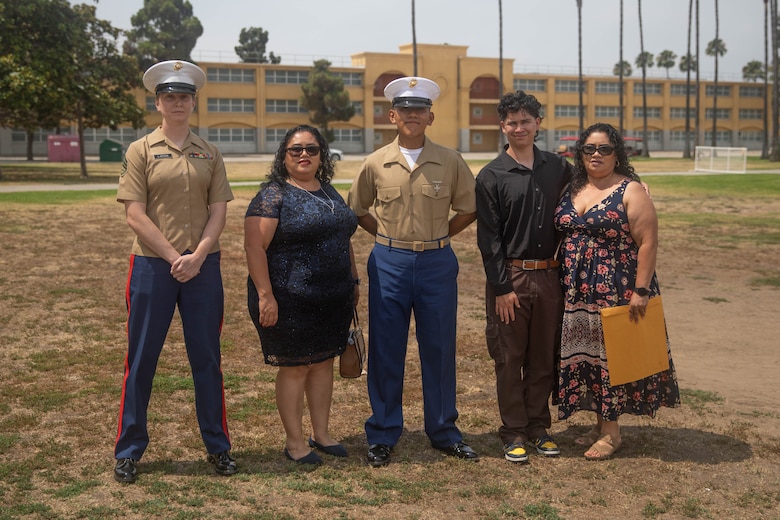 U.S. Marine Corps Pvt. Carlos Paz-Sosa, center, a Marine with India Company, 3rd Recruit Training Battalion, Recruit Training Regiment, and Staff Sgt. Aubrey Larsen, Paz-Sosa's recruiter in Riverside County, California, far left, and family members pose for a group photo following a graduation ceremony at Marine Corps Recruit Depot San Diego, California, July 12, 2024. Paz-Sosa was highlighted due to his impressive transformation, losing more than 100 lbs. in order to become a Marine. (U.S. Marine Corps photo by Cpl. Elliott A. Flood-Johnson)