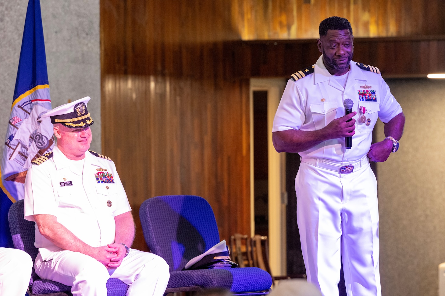 Cmdr. Omari D. Buckley, right, outgoing commander, Military Sealift Command Ship Support Unit Guam, speaks to the audience during the SSU Guam change of command ceremony in the base chapel at Naval Base Guam, July 12, 2024. (Navy photo by Grady T. Fontana)