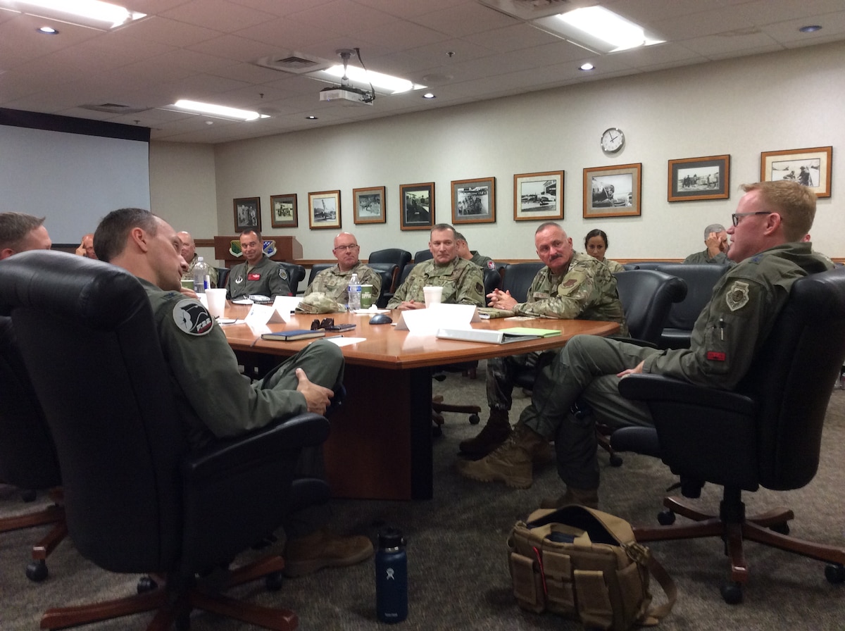 A group of military members sitting around a conference table.