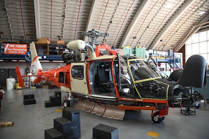 A Coast Guard MH-65 Dolphin helicopter sits on the work floor at the Coast Guard Aviation Logistics Center (ALC) located on Coast Guard Base Elizabeth City in Elizabeth City, North Carolina, Sep. 20, 2023.