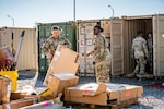 Soldiers remove boxes from storage containers