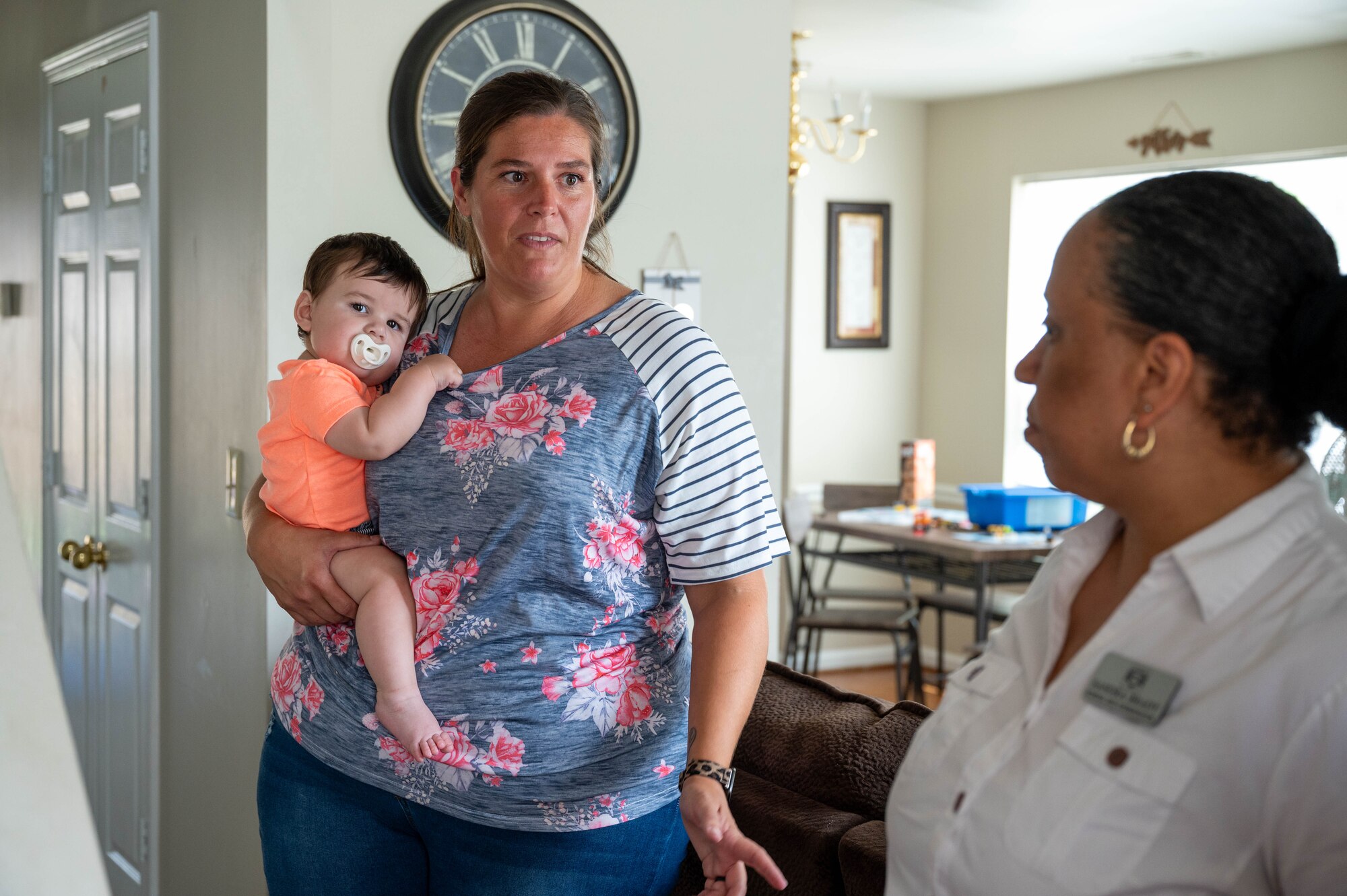 Krista Cox, a Family Child Care provider, holds a child under her care following the opening of the newest Family Child Care home at Joint Base Anacostia-Bolling, Washington, D.C., July 10, 2024. Cox has stated that watching the children under her care learn from each other is her biggest inspiration. (U.S. Air Force photo by Hayden Hallman)