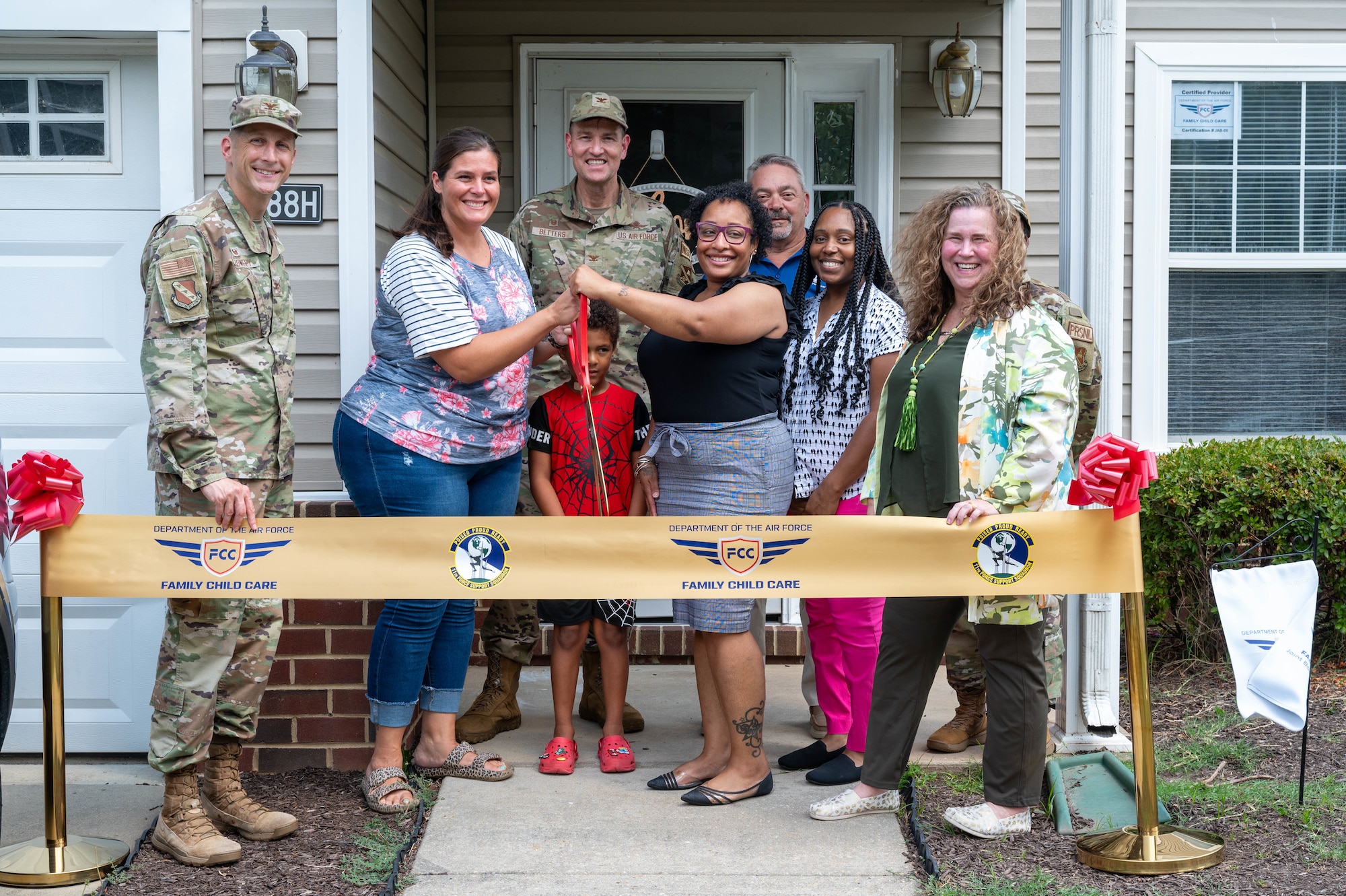 Joint Base Anacostia-Bolling command team members and members of the Family Child Care program prepare to cut a ribbon outside of the newest Family Child Care home at Joint Base Anacostia-Bolling, Washington, D.C., July 10, 2024. This marks the sixth Family Child Care home in the JBAB community. (U.S. Air Force photo by Hayden Hallman)