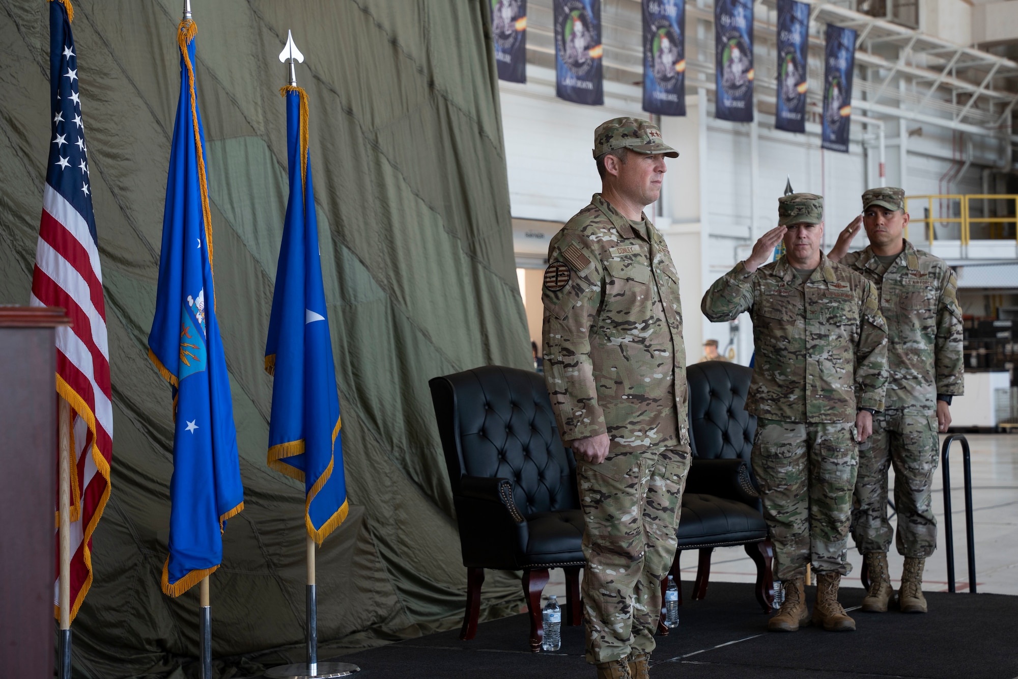 U.S. Air Force Lt. Gen. Michael Conley, left, Air Force Special Operations Command commander, is saluted by U.S. Air Force Col. Jeremy Bergin, center, 27th Special Operations Wing outgoing commander, and  U.S. Air Force Col. Robert Johnston, 27th Special Operations Wing incoming commander, Cannon Air Force Base, New Mexico, July 15, 2024. Conley facilitated the transfer of command from Bergin to Johnston. (U.S. Air Force photo by Tech. Sgt. Kaylee Clark)