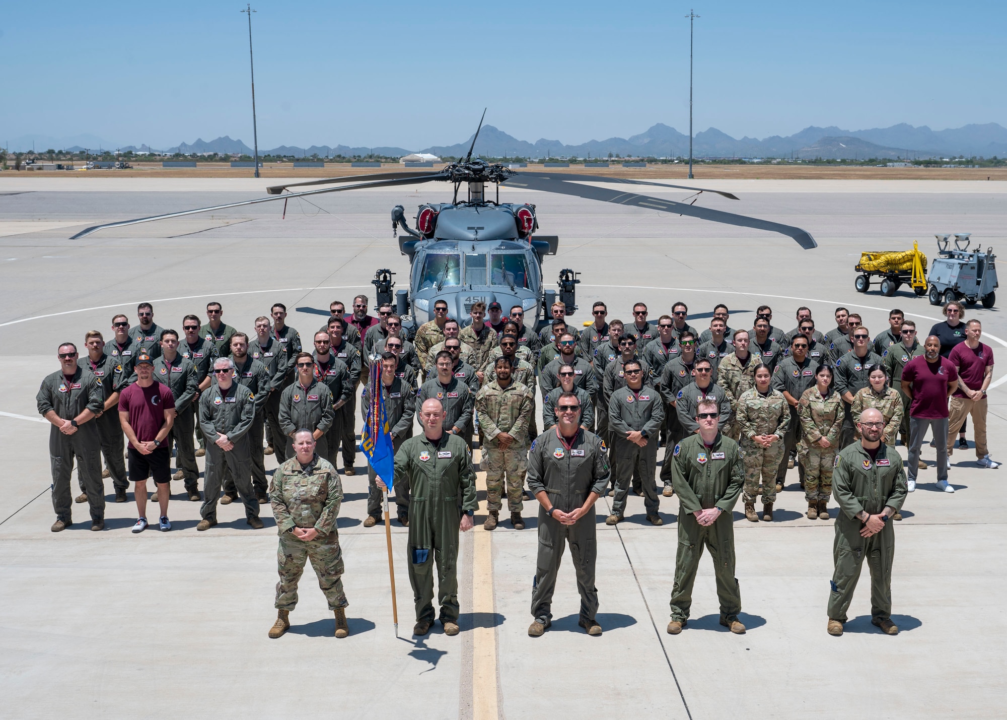 The 55th Rescue Squadron poses for a group photo at Davis-Monthan Air Force Base, Ariz., July 12, 2024. The 55th Rescue Squadron operates the HH-60G Pave Hawk, as well as the HH-60W Jolly Green II, to provide rapidly deployable combat search and rescue forces to theater commanders worldwide. They tactically employ the HH-60G/W helicopters and their crews in hostile environments to recover downed aircrew and isolated personnel during day or night, and during marginal weather conditions. (U.S. Air Force photo by Airman 1st Class William Finn V)