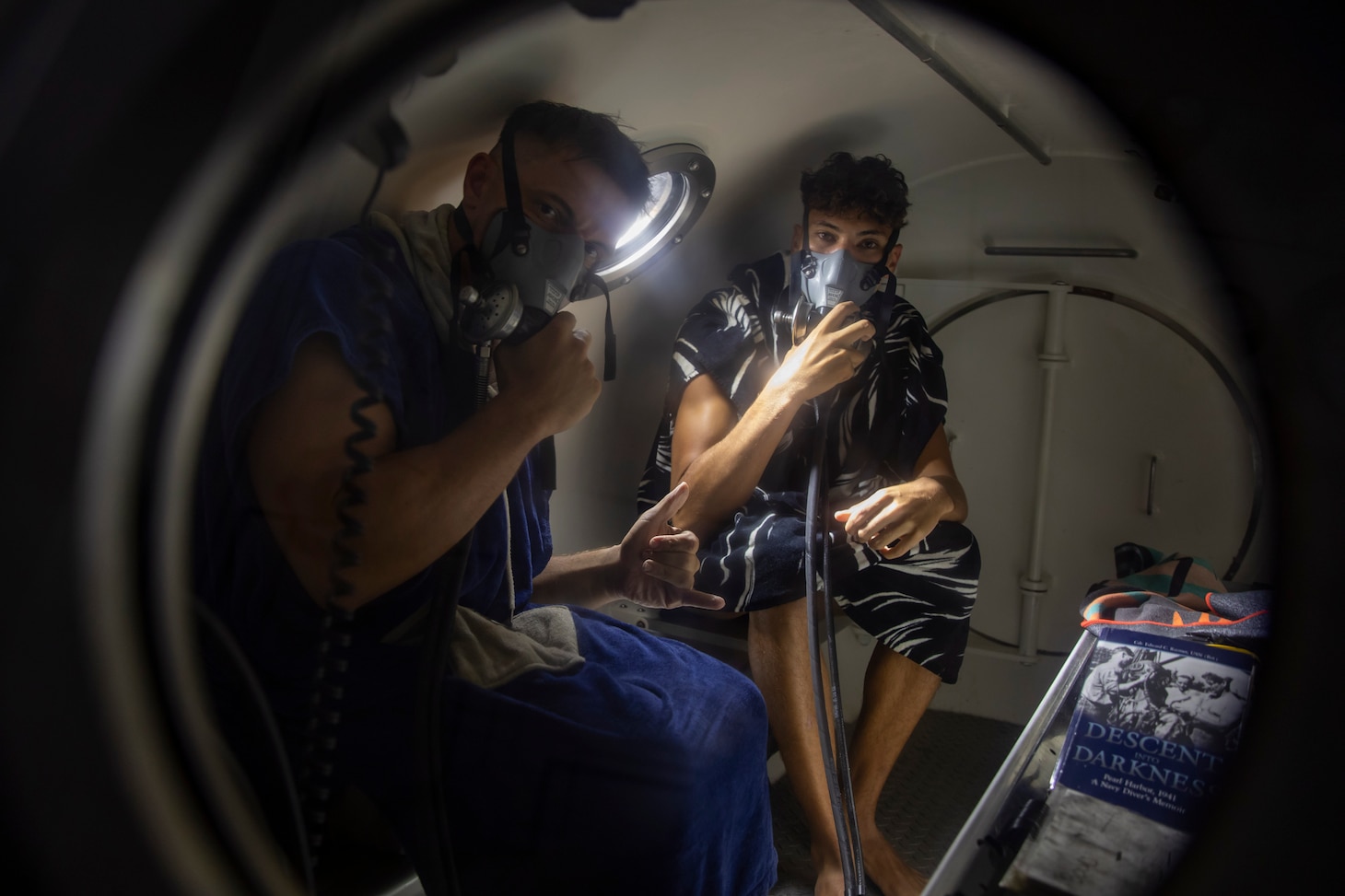 240709-N-WM182-1079 NHA TRANG, Vietnam (July 9, 2024) U.S. Army Sgt. Devin Rhodes and Spc. Christian Roscios, deep sea divers assigned to the Defense POW/MIA Accounting Agency (DPAA) sit in a decompression chamber aboard a dive barge supporting the DPAA investigation of a 1971 helicopter crash site in the Bay of Nha Trang after completing a dive July 9. U.S. 7th Fleet is the U.S. Navy's largest forward-deployed numbered fleet, and routinely interacts and operates with allies and partners in preserving a free and open Indo-Pacific region. (U.S. Navy Photo by Mass Communication Specialist 2nd Class Caitlin Flynn)