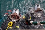 240709-N-WM182-1096 NHA TRANG, Vietnam (July 9, 2024) Deep sea divers assigned to the Defense POW/MIA Accounting Agency (DPAA) prepare to dive alongside a dive barge supporting the DPAA investigation of a 1971 helicopter crash site in the Bay of Nha Trang July 9. U.S. 7th Fleet is the U.S. Navy's largest forward-deployed numbered fleet, and routinely interacts and operates with allies and partners in preserving a free and open Indo-Pacific region. (U.S. Navy Photo by Mass Communication Specialist 2nd Class Caitlin Flynn)