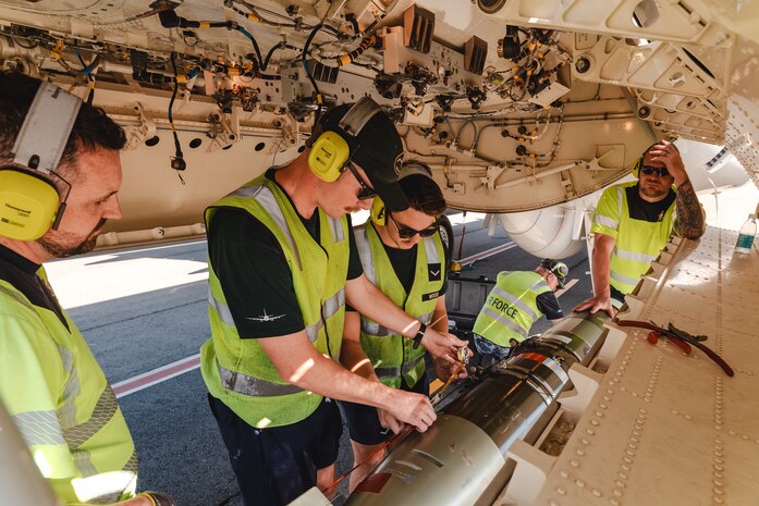 Air Force aviators from No. 11 Squadron, CPL Brendan King, CPL Zachary Sellman, LAC Joe Woods, CPL Aaron Sims, fit a Mk54 Lightweight Exercise Torpedo to a Royal Australian Air Force P-8A Poseidon during Exercise Rim of the Pacific (RIMPAC) 2024, at Joint Base Pearl Harbor-Hickam, Hawaii.