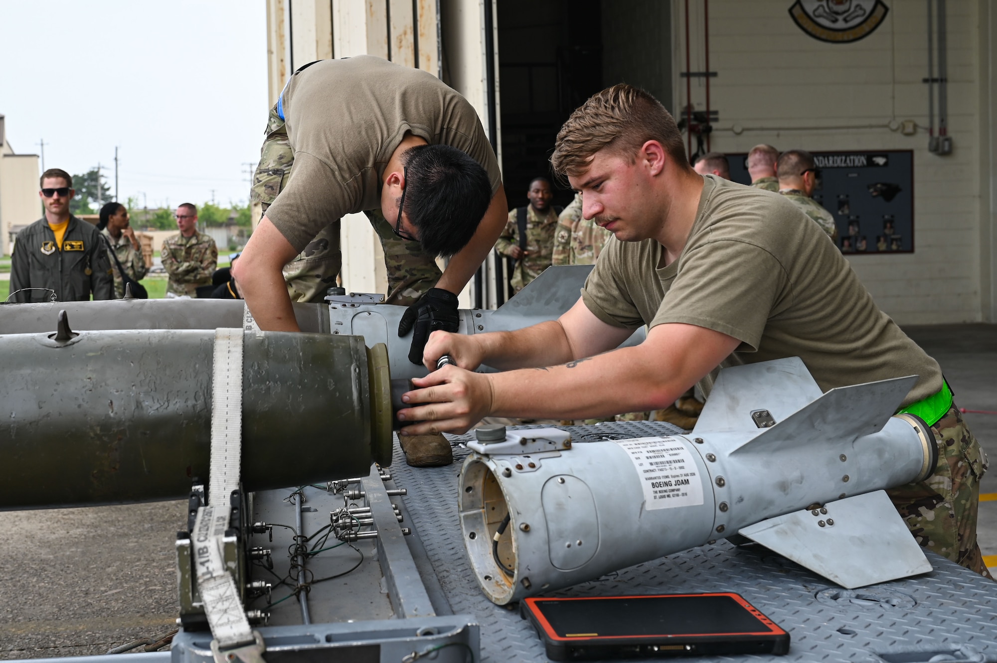Senior Airman Tommy Tang, left,  and Staff Sgt. Alec Linn, 8th Maintenance Squadron conventional maintenance crew chiefs, prepare a munition for loading during the 2024 2nd Quarter Dedicated Crew Chief and Load Crew Competition,