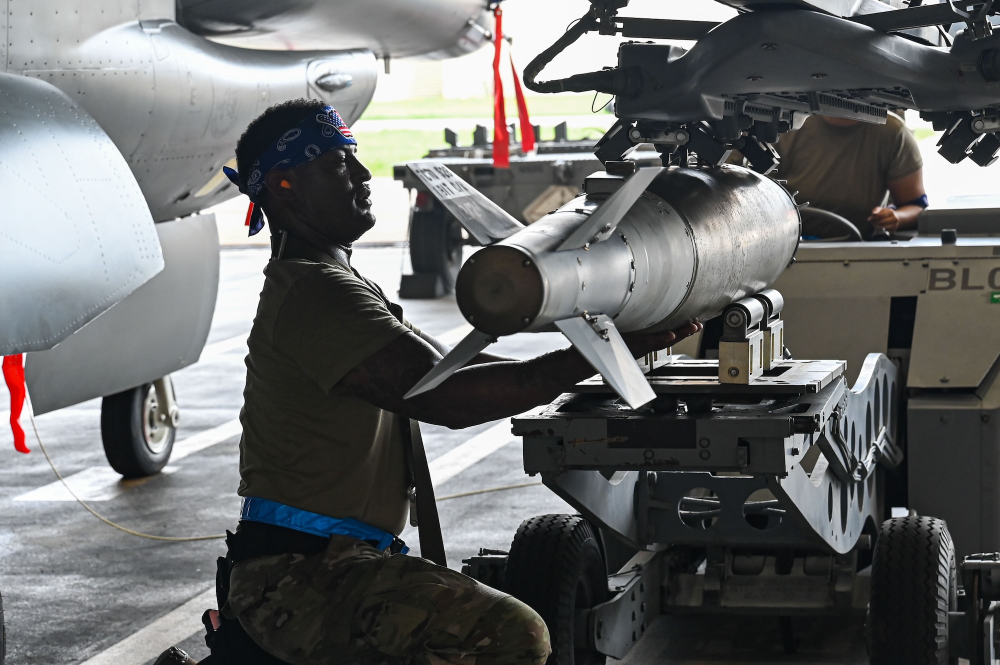 U.S. Air Force Staff Sgt. Michael Holloway, 35th Fighter Generation Squadron weapons crew team chief, adjusts the position of a munition during the 2024 2nd Quarter Dedicated Crew Chief and Load Crew Competition.