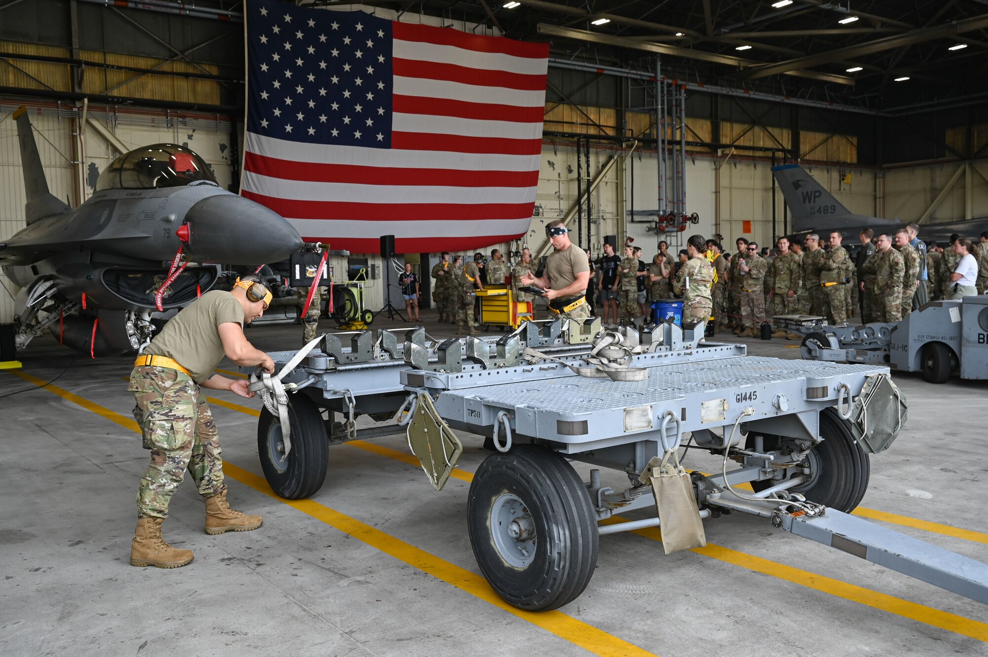 Senior Airman Nicholas Velazquez, left, 80th Fighter Generation Squadron weapons loader, and Staff Sgt. Levi West, 80th FGS weapons team chief, load munitions during the 2024 2nd Quarter Dedicated Crew Chief and Load Crew Competition.