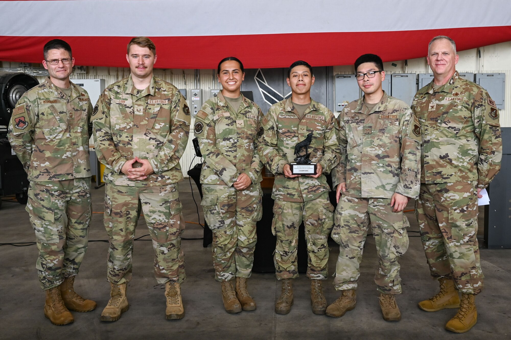 U.S. Air Force Col. Casey Crabill, right, 8th Maintenance Group commander, and Chief Master Sgt. Nathan Bouchard, left, 8th MXG command chief, congratulate members assigned to the 8th Maintenance Squadron for winning the bomb building portion of the 2024 2nd Quarter Dedicated Crew Chief and Load Crew Competition.