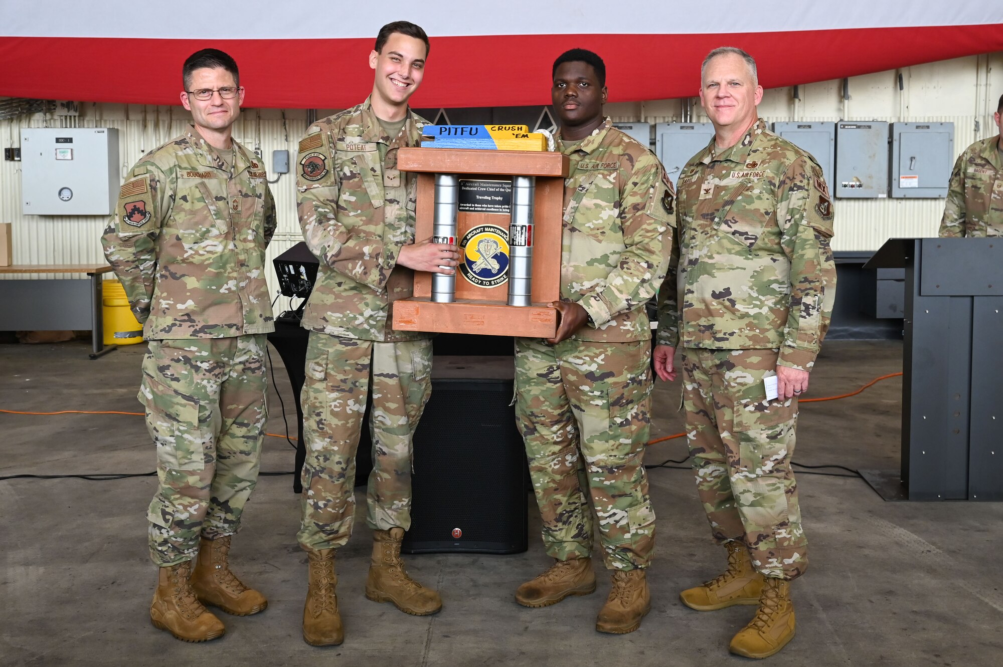 U.S. Air Force Col. Casey Crabill, right, 8th Maintenance Group commander, and Chief Master Sgt. Nathan Bouchard, left, 8th MXG command chief, congratulate members assigned to the 35th Fighter Generation Squadron during the 2024 2nd Quarter Dedicated Crew Chief and Load Crew Competition.