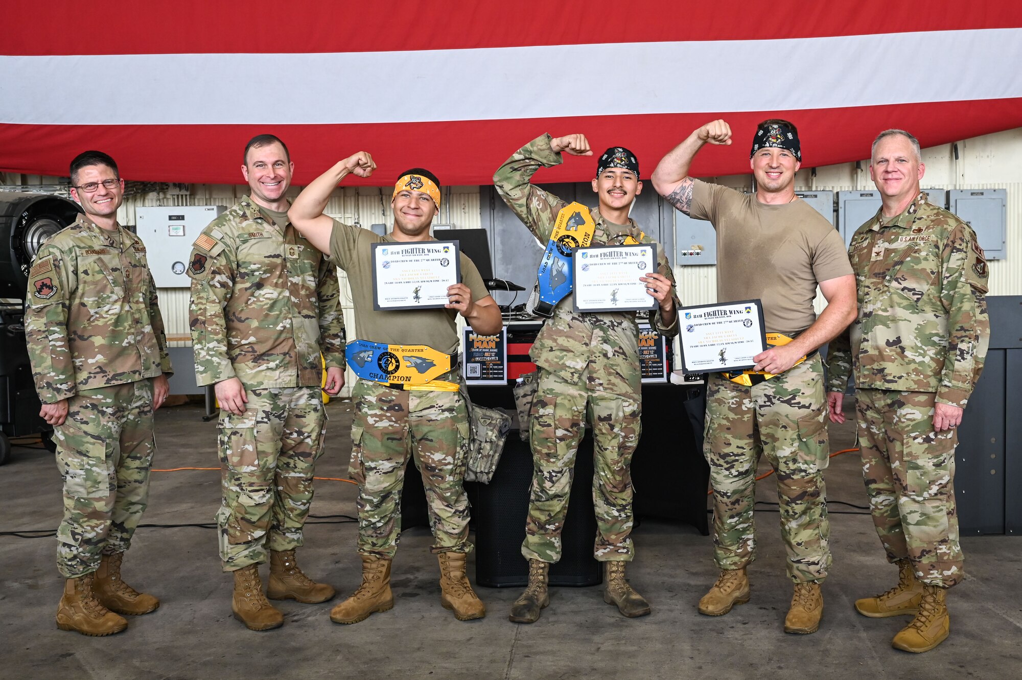 U.S. Air Force Col. Casey Crabill, right, 8th Maintenance Group commander, and Chief Master Sgt. Nathan Bouchard, left, 8th MXG command chief, congratulate members assigned to the 80th Fighter Generation Squadron for winning the load crew team of the quarter.