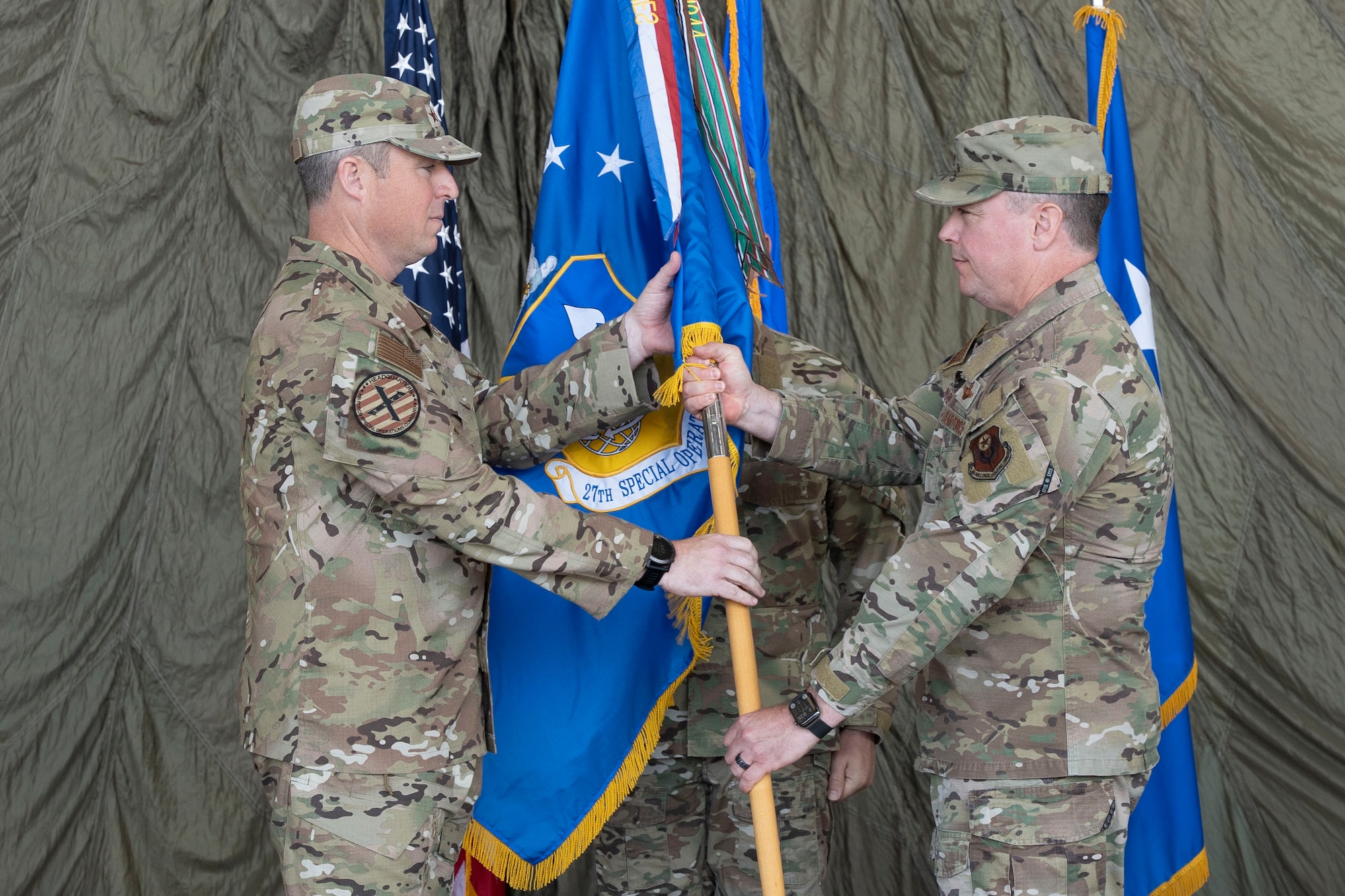 U.S. Air Force Lt. Gen. Michael Conley, left, Air Force Special Operations Command commander, receives the wing guidon from U.S. Air Force Col. Jeremy Bergin, 27th Special Operations Wing outgoing commander, during a change of command ceremony, Cannon Air Force Base, New Mexico, July 15, 2024. During his command, Bergin led the Steadfast Line rebranding of the wing, honoring the legacy of the 27th Bombardment Group Airmen who held the line during World War II. (U.S. Air Force photo by Tech. Sgt. Kaylee Clark)