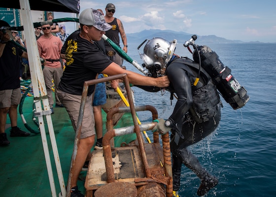 240709-N-WM182-1056 NHA TRANG, Vietnam (July 9, 2024) U.S. Army Sgt. Devin Rhodes, a deep sea diver assigned to the Defense POW/MIA Accounting Agency (DPAA), exits the water aboard a dive barge supporting the DPAA investigation of a 1971 helicopter crash site in the Bay of Nha Trang July 9. U.S. 7th Fleet is the U.S. Navy's largest forward-deployed numbered fleet, and routinely interacts and operates with allies and partners in preserving a free and open Indo-Pacific region. (U.S. Navy Photo by Mass Communication Specialist 2nd Class Caitlin Flynn)