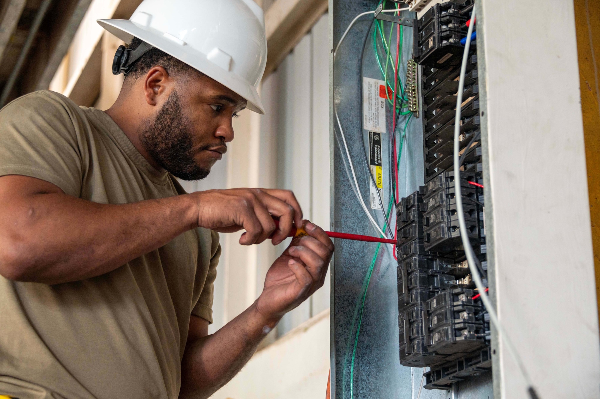 Photo of an Airman working on an electrical box