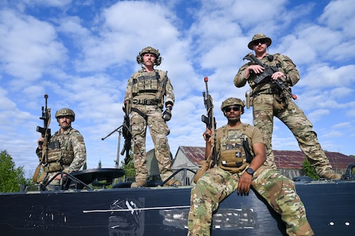 Staff Sgt. Christopher Gangeme, center, 136th Contingency Response Flight security forces team leader, left, Staff Sgt. Joseph Hunn, right 136th CRF security forces second in command, Staff Sgt. Cameron Wentworth, center left, CRF security forces defender, and Staff Sgt. Samuel Alexander Wells, center right, CRF security forces defender posed for a photo after performing advanced field training scenarios with team members from the 433rd Contingency Response Squadron at the Contingency Location Operations Rehearsal (CLOR 24) in Alpena, Michigan June 27, 2024.