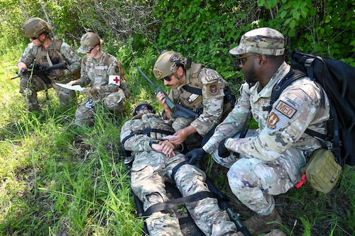 Staff Sgt. Christopher Gangeme, center, 136th Contingency Response Flight security forces team leader, Staff Sgt. Virgil Salidavar, center right, 433rd CRF specialist, and Staff Sgt. Kaden Ables, left, 433rd CRF specialist, trained alongside Senior Airman Erica Nolting, 72nd Operational Medical Readiness Squadron medical technician and Senior Airman Isaac Williams, 72nd Healthcare Operations Squadron medical technician at the Contingency Location Operations Rehearsal (CLOR 24) in Alpena, Michigan June 26, 2024.