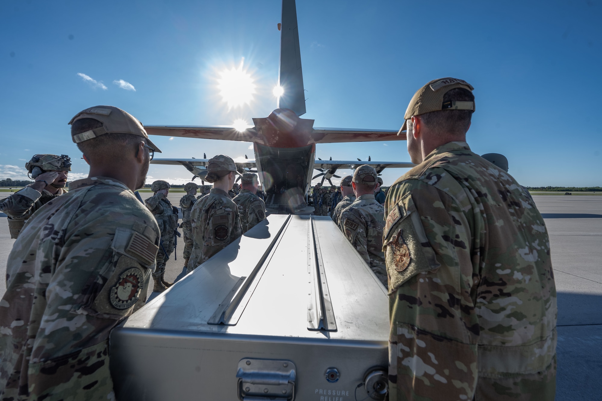 Airmen load a box onto an aircraft.