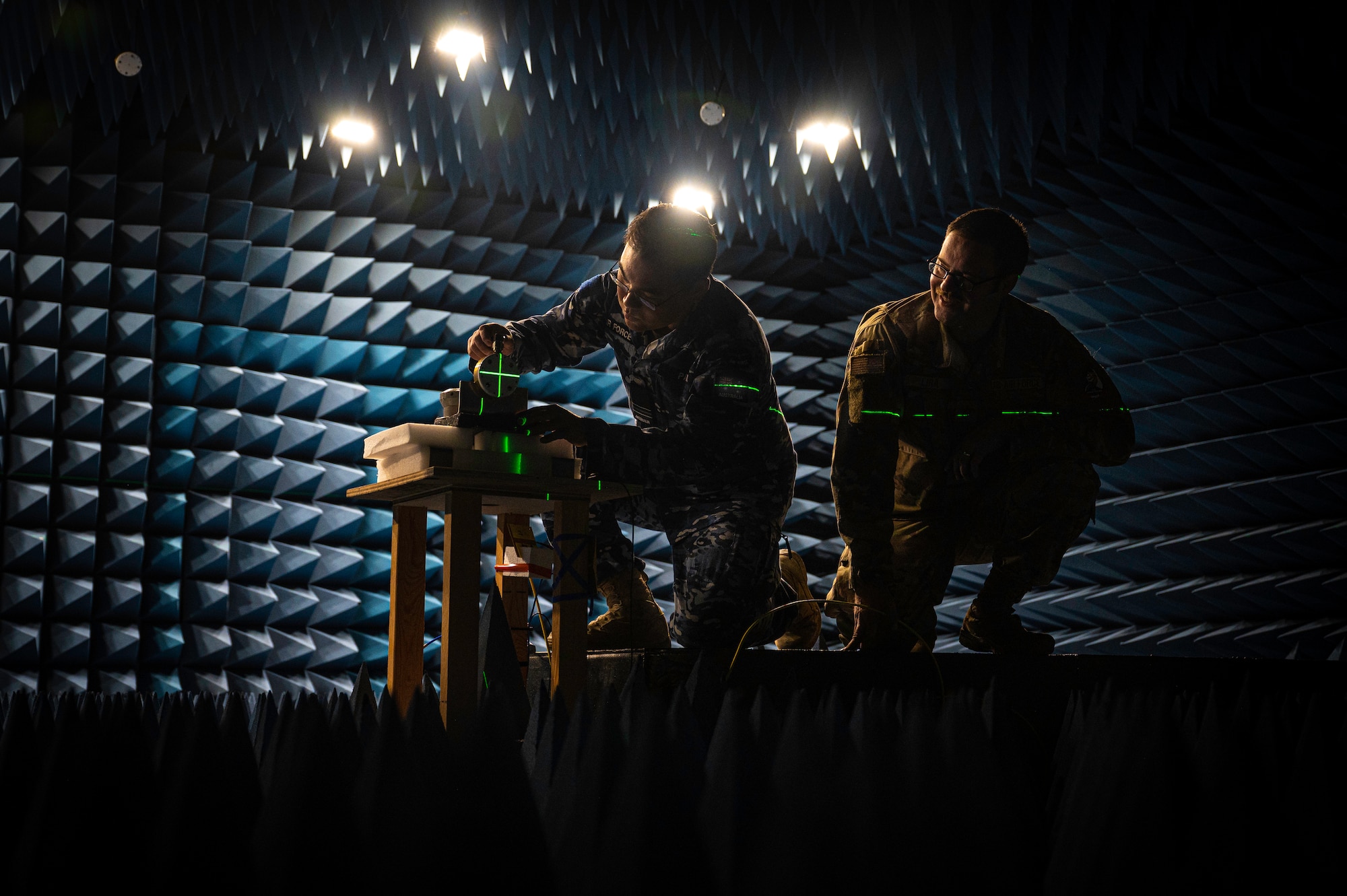 Two men work in a room designed to rest sound and radio waves.