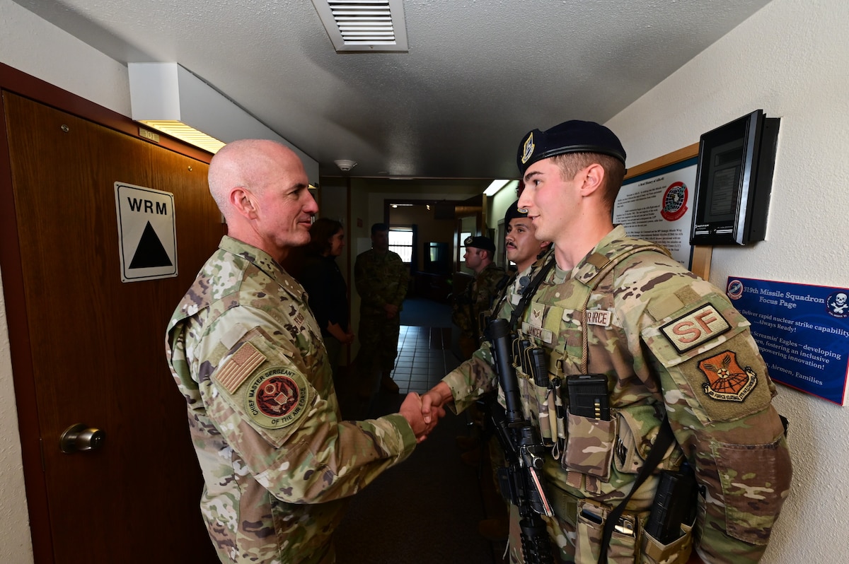Chief Master Sgt. of the Air Force David Flosi shakes hands with Senior Airman Jarrett Jancek, defender with the 90th Missile Security Forces Squadron, during a visit to the A-01 missile alert facility near Pine Bluffs, Wyoming, July 2, 2024. Flosi visited the 90th Missile Wing at F.E. Warren Air Force Base, Wyoming, and the missile field to witness how Airmen continue to provide 24/7 strategic deterrence, standing ready to respond at a moment’s notice in support of the most responsive leg of the nuclear triad. (U.S. Air Force photo by Glenn S. Robertson)