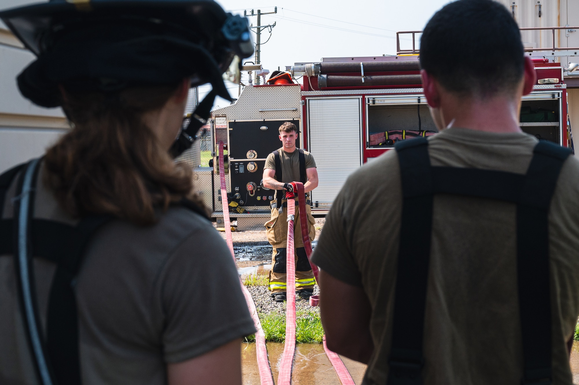 Senior Airman Dylan Antonson, 8th Civil Engineering Squadron driver operator, rolls up a hose.